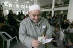 لحج نيوز - فلسطيني يعد أموال تعويض عن بيته المدمر